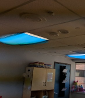 Before: blue tablecloths and tissue draped under fluorescent fixtures at Judson Center