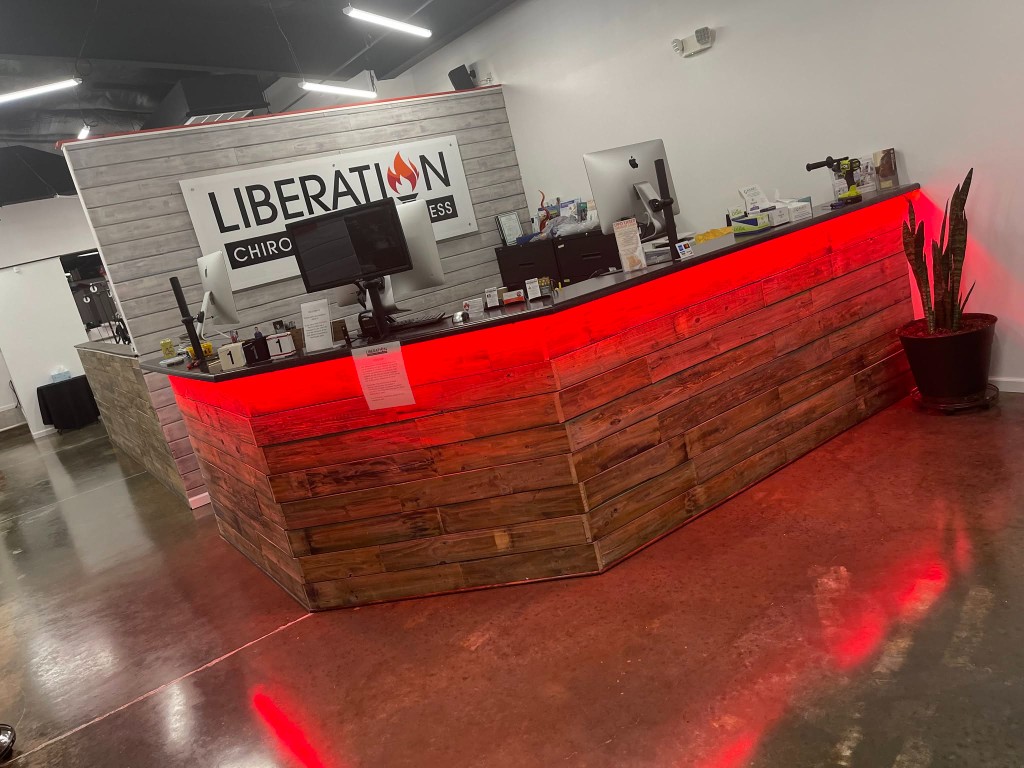 Liberation Chiropractic reception desk with red under-counter accent lighting