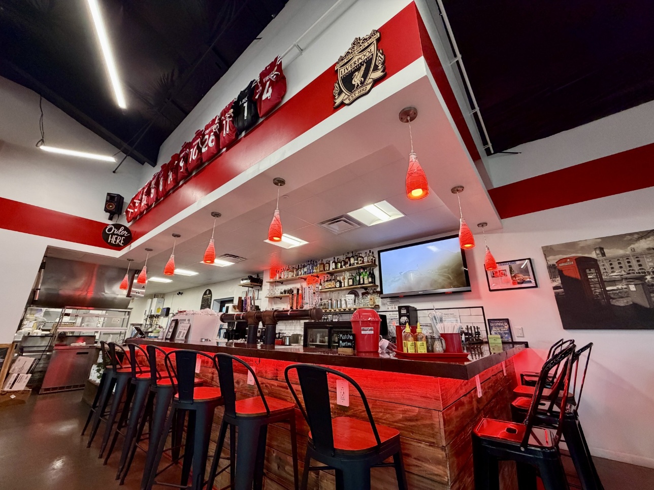 REDBAR wrap-around bar with red pendant lights, ColorTune troffers, and red under-counter accent lighting